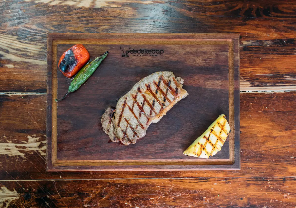Dede Kebap'ta k&ouml;m&uuml;rde pişmiş New York steak; kenarında yağ şeridi g&ouml;r&uuml;nen kontrfile